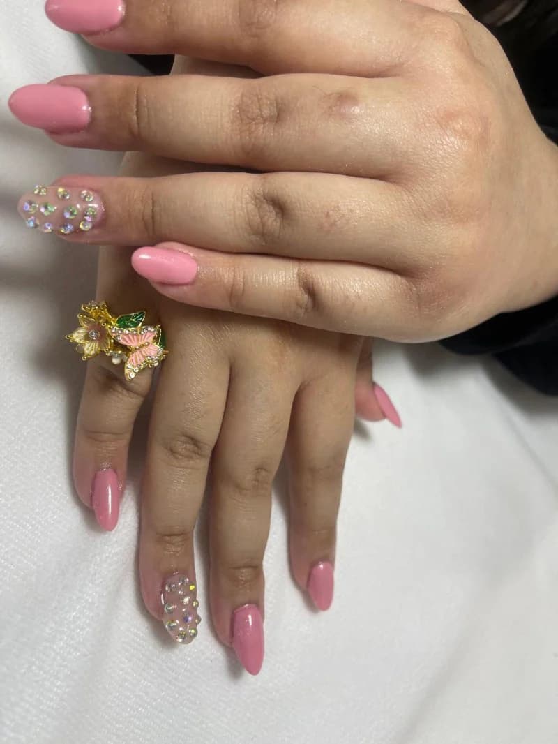 Bubblegum pink gel nails with rhinestone-studded accent nails