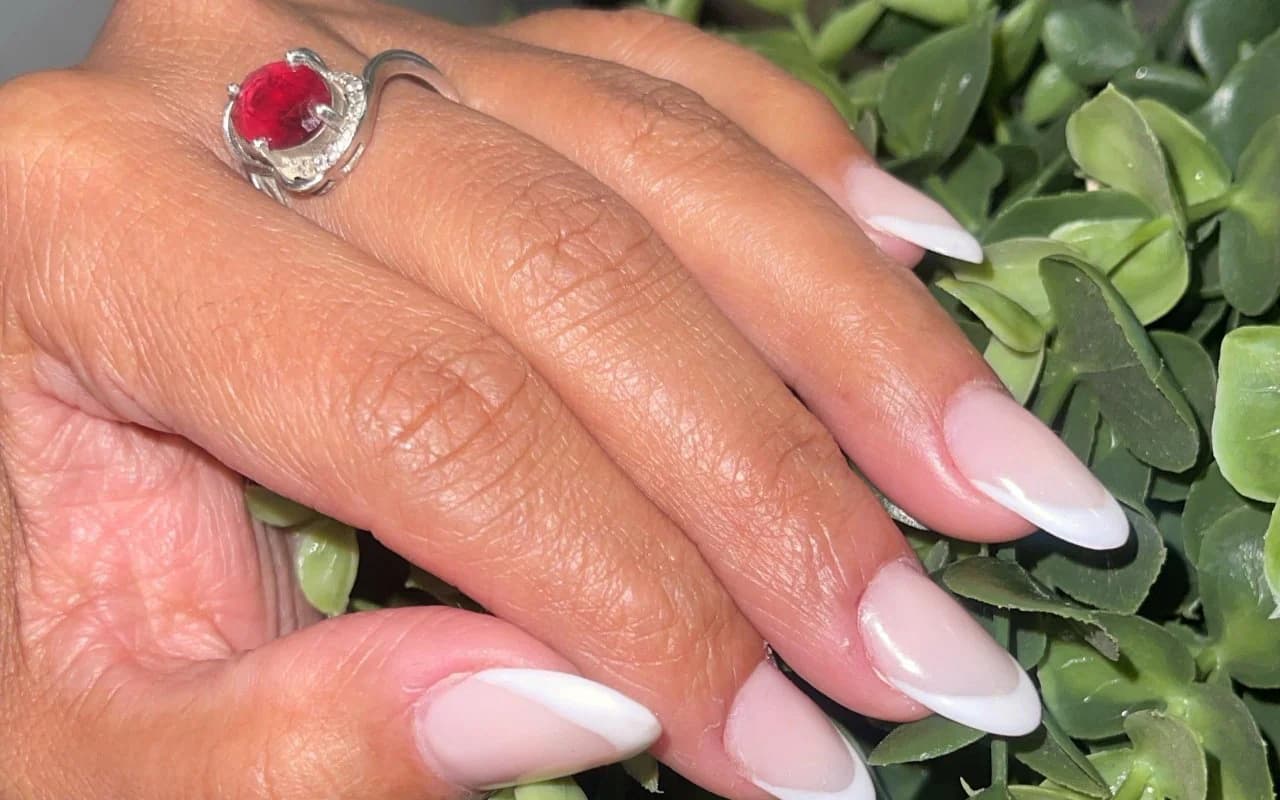 Classic white French almond extensions on a natural pink base