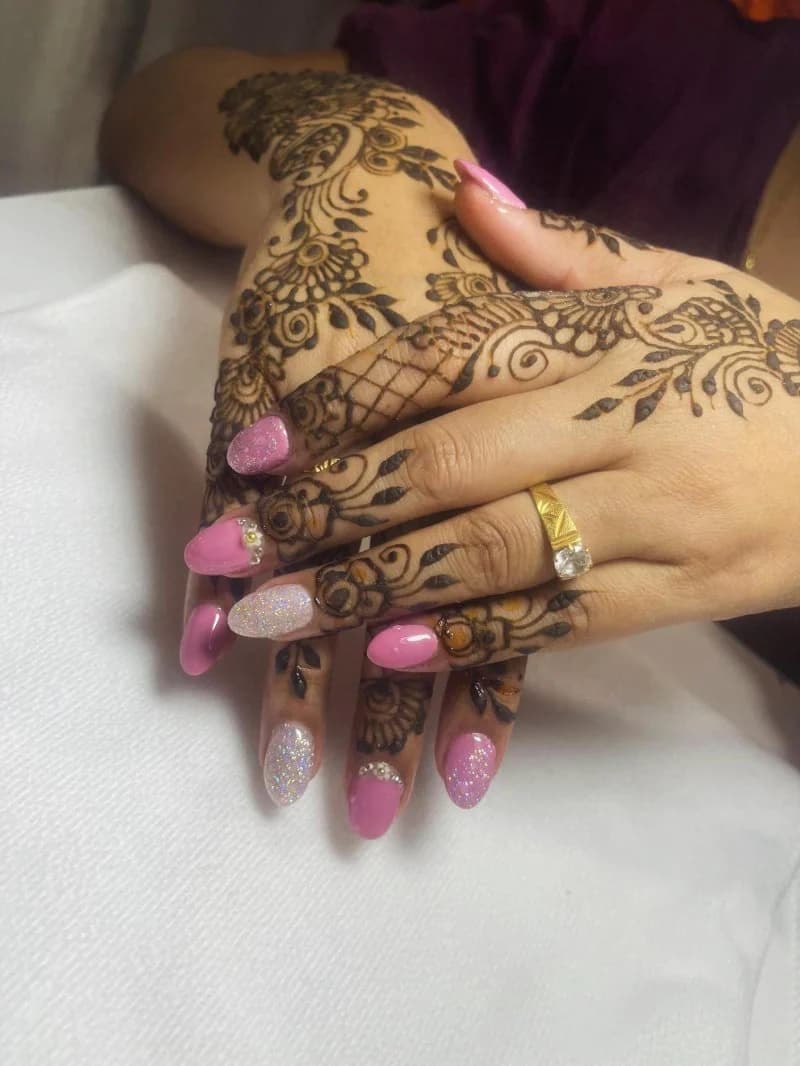 Intricate henna across both hands, paired with pink glitter almond nails