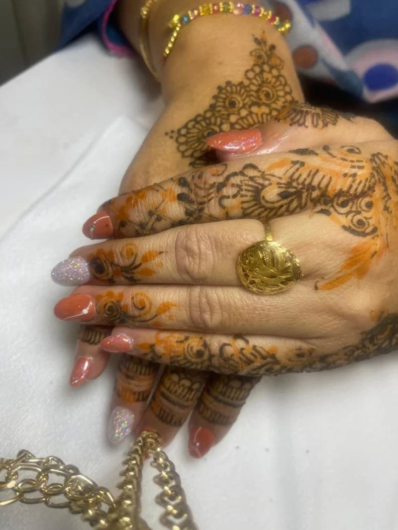 Freshly stained henna on both hands with terracotta and glitter nails and gold jewellery