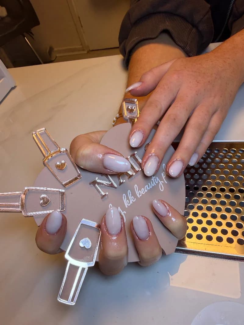 Milky nude gel on short, neatly shaped nails