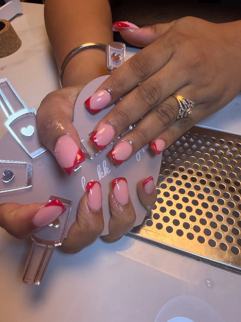 Sheer pink nails with a slim red French tip