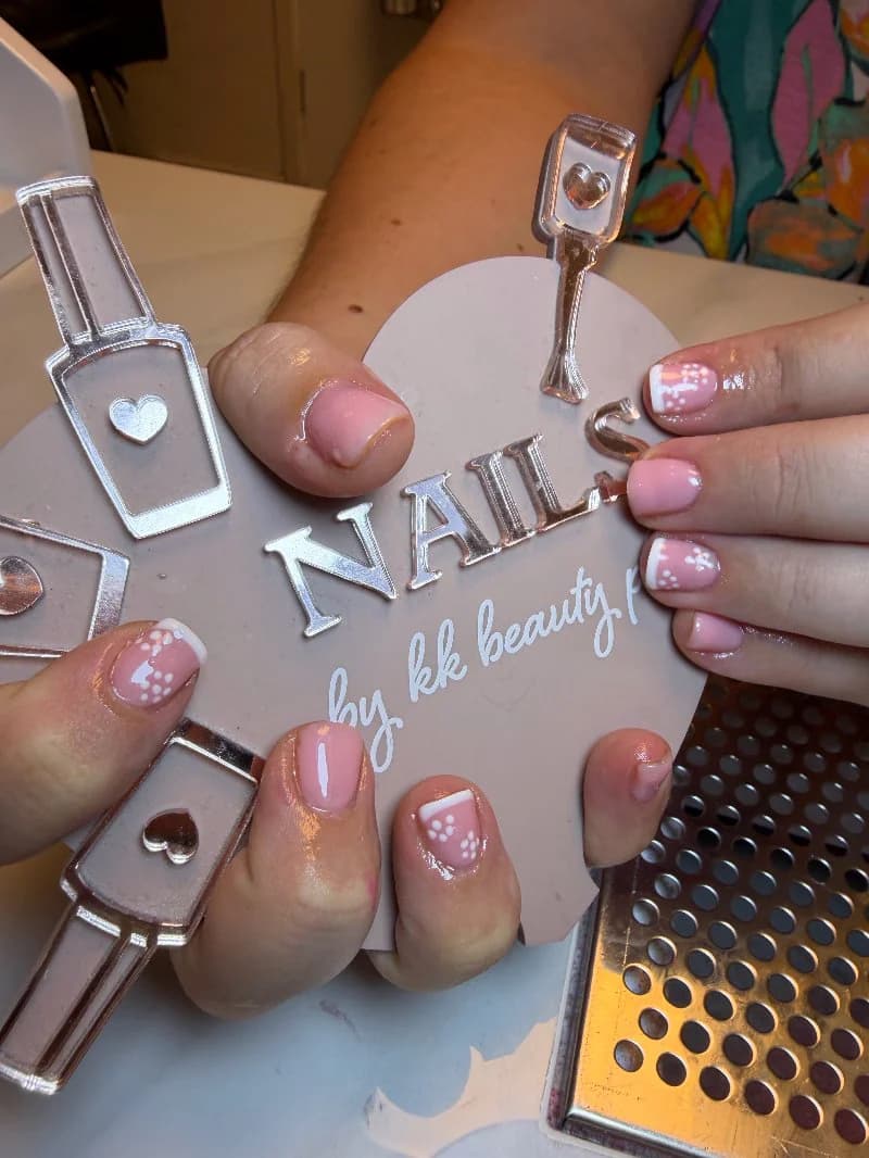 Sheer pink nails with tiny hand-painted white flowers