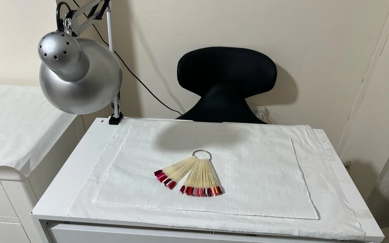 The manicure desk with its task lamp, client chair and a fan of colour sample tips