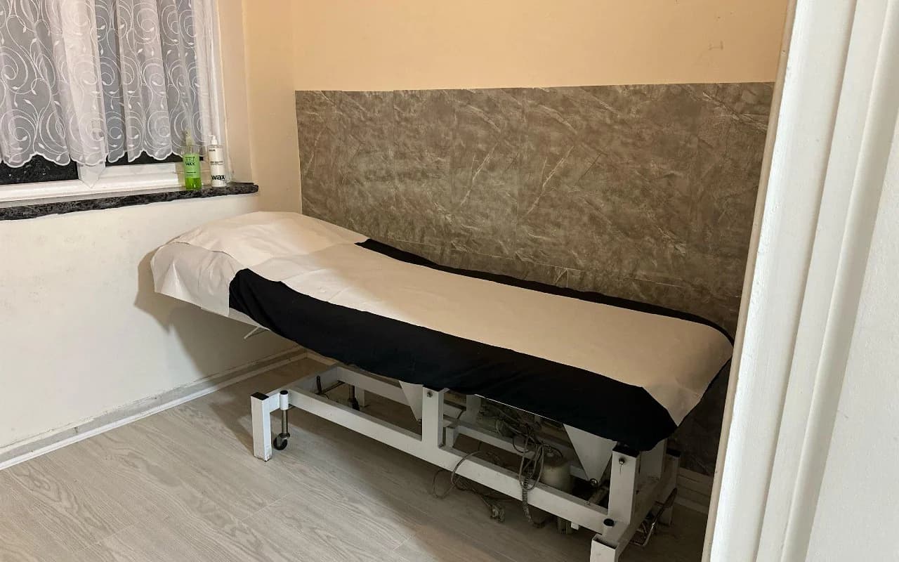 The private waxing and facial room with a freshly prepared treatment couch