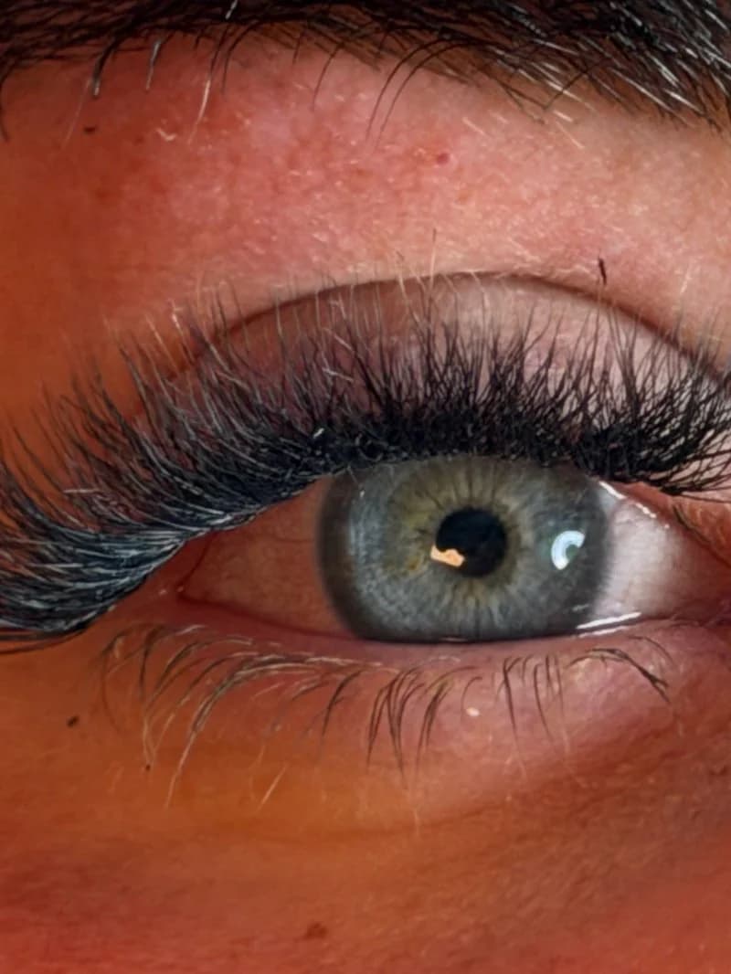 Full volume lash extensions, close up on a green eye